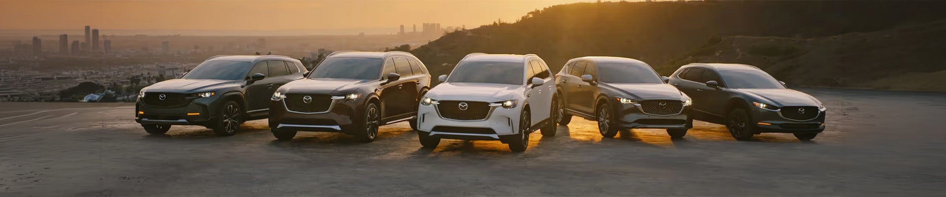 Mazda vehicles lined up in sunset